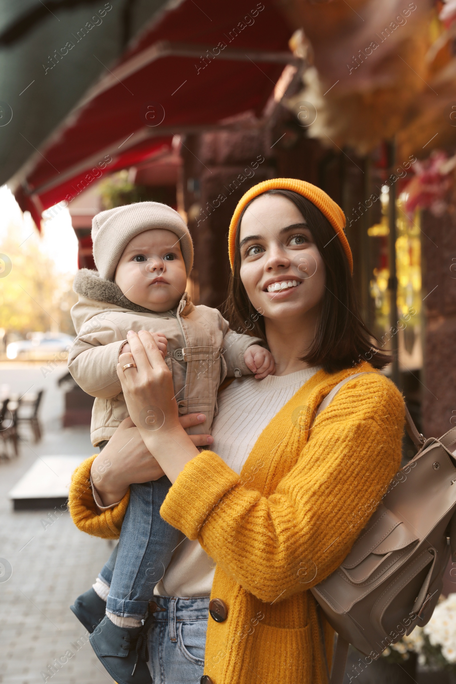 Photo of Happy mother with her baby son near outdoor cafe