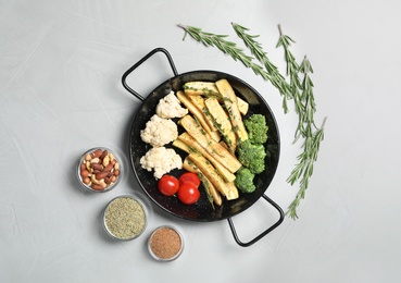 Photo of Flat lay composition with raw white carrot and vegetables in frying pan on light grey table