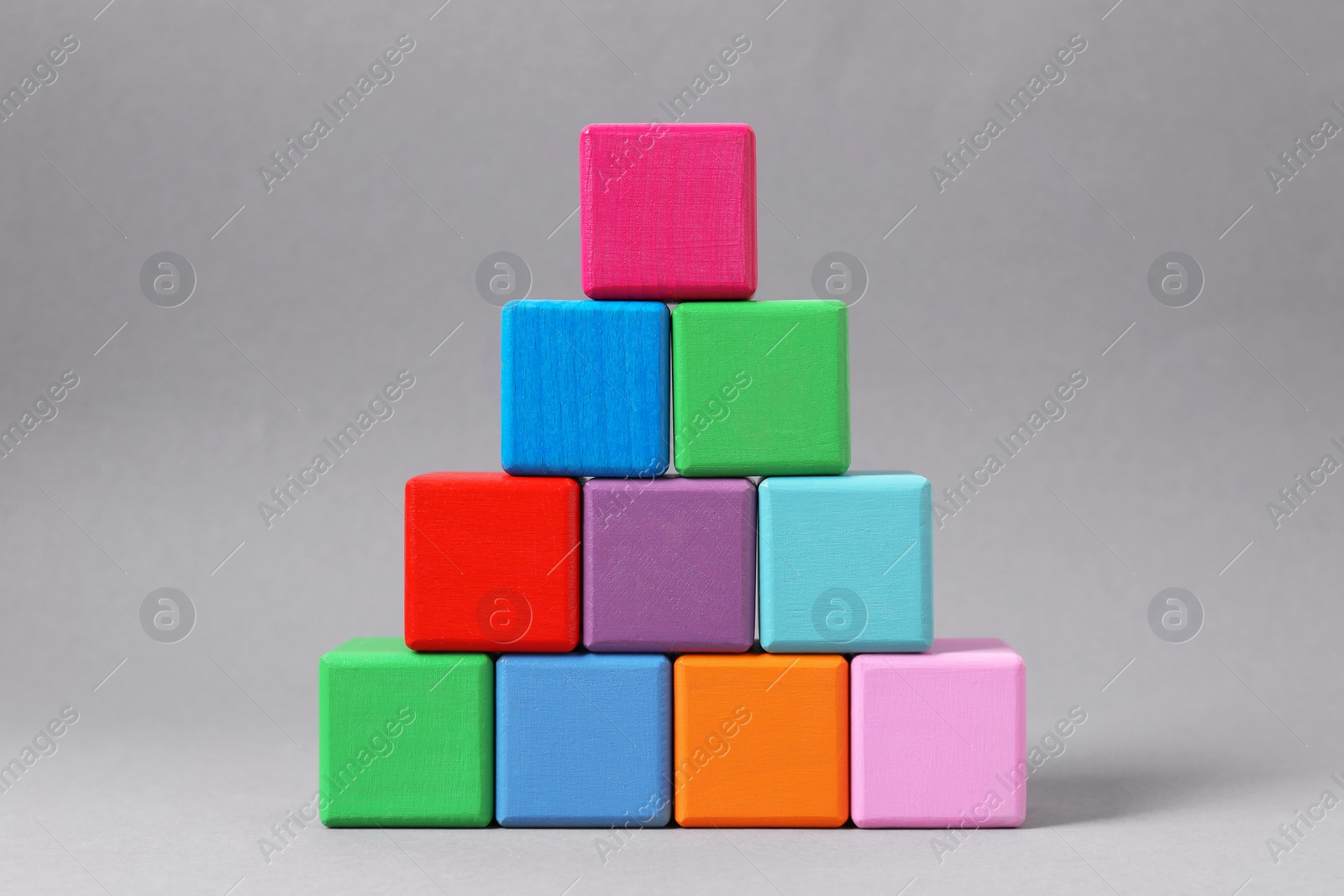 Photo of Pyramid of blank colorful wooden cubes on light grey background