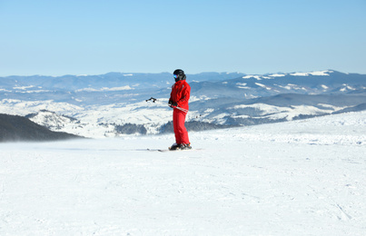Male skier on snowy slope in mountains. Winter vacation