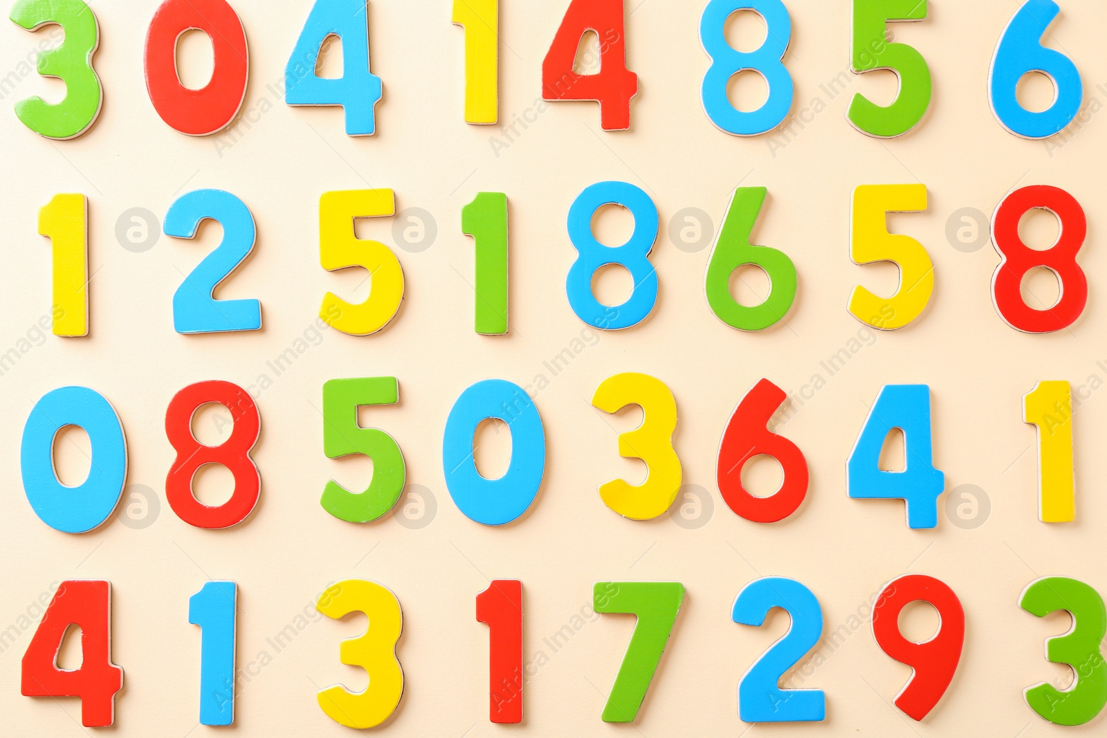 Photo of Colorful numbers on beige background, flat lay