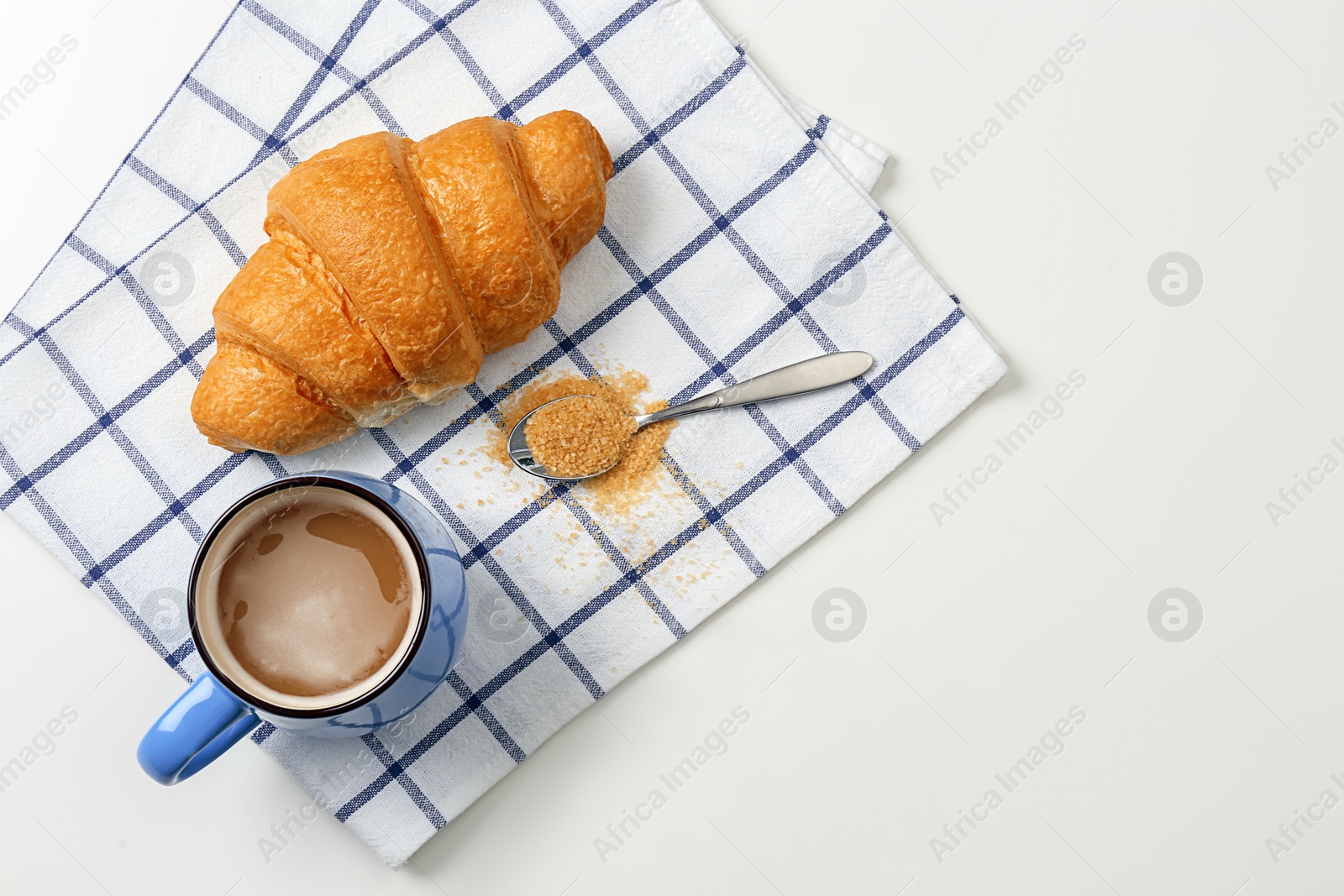 Photo of Tasty croissant and cup of coffee on light background, top view