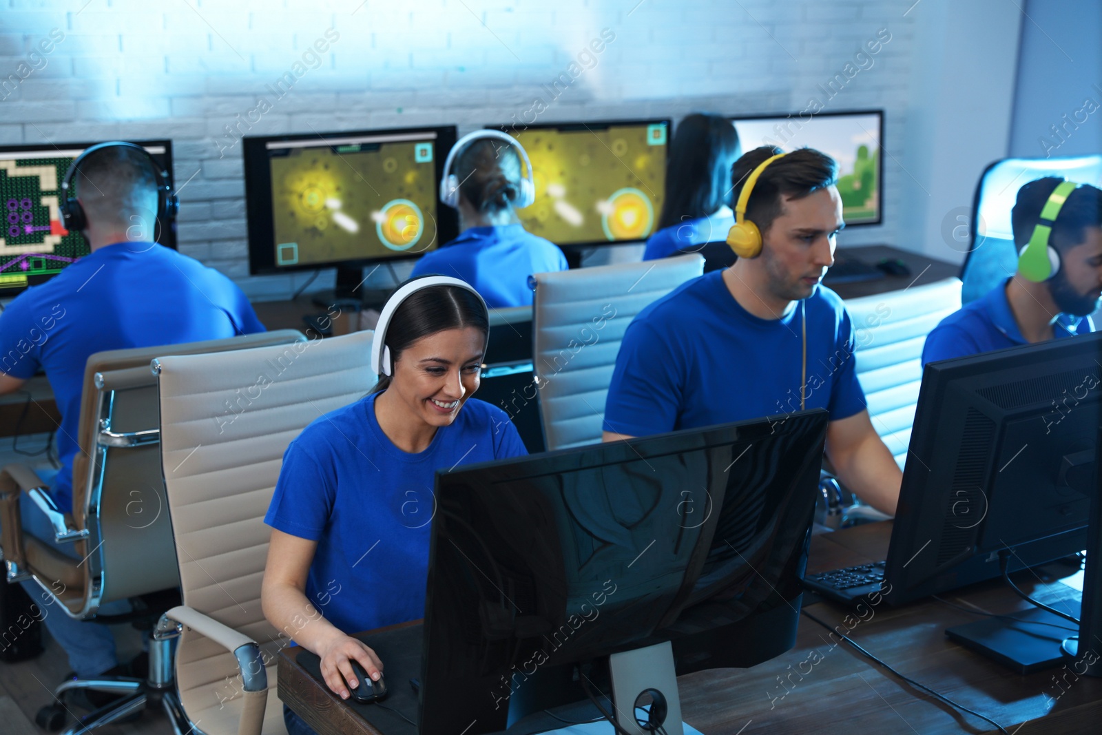 Photo of Young people playing video games on computers indoors. Esports tournament