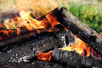 Metal brazier with burning wood outdoors, closeup