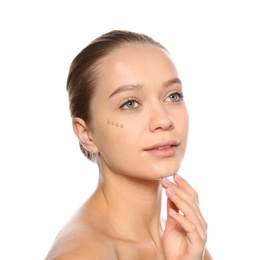 Photo of Portrait of young woman with liquid foundation on her face against white background