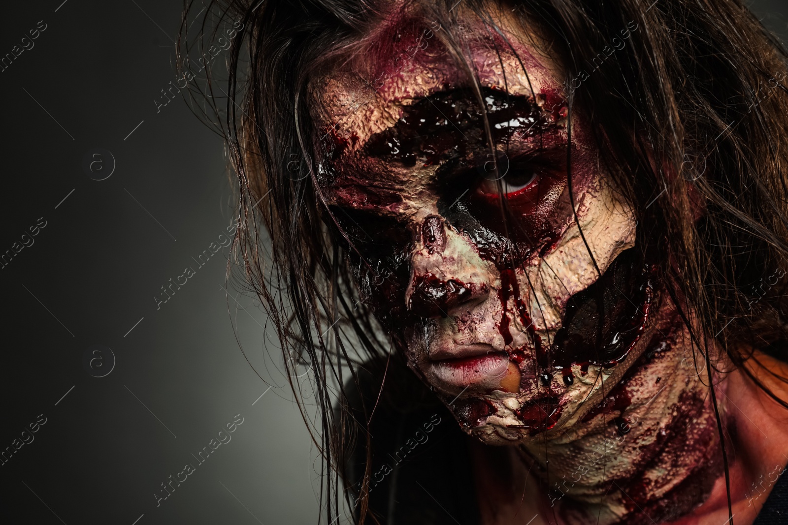 Photo of Scary zombie on dark background, closeup. Halloween monster