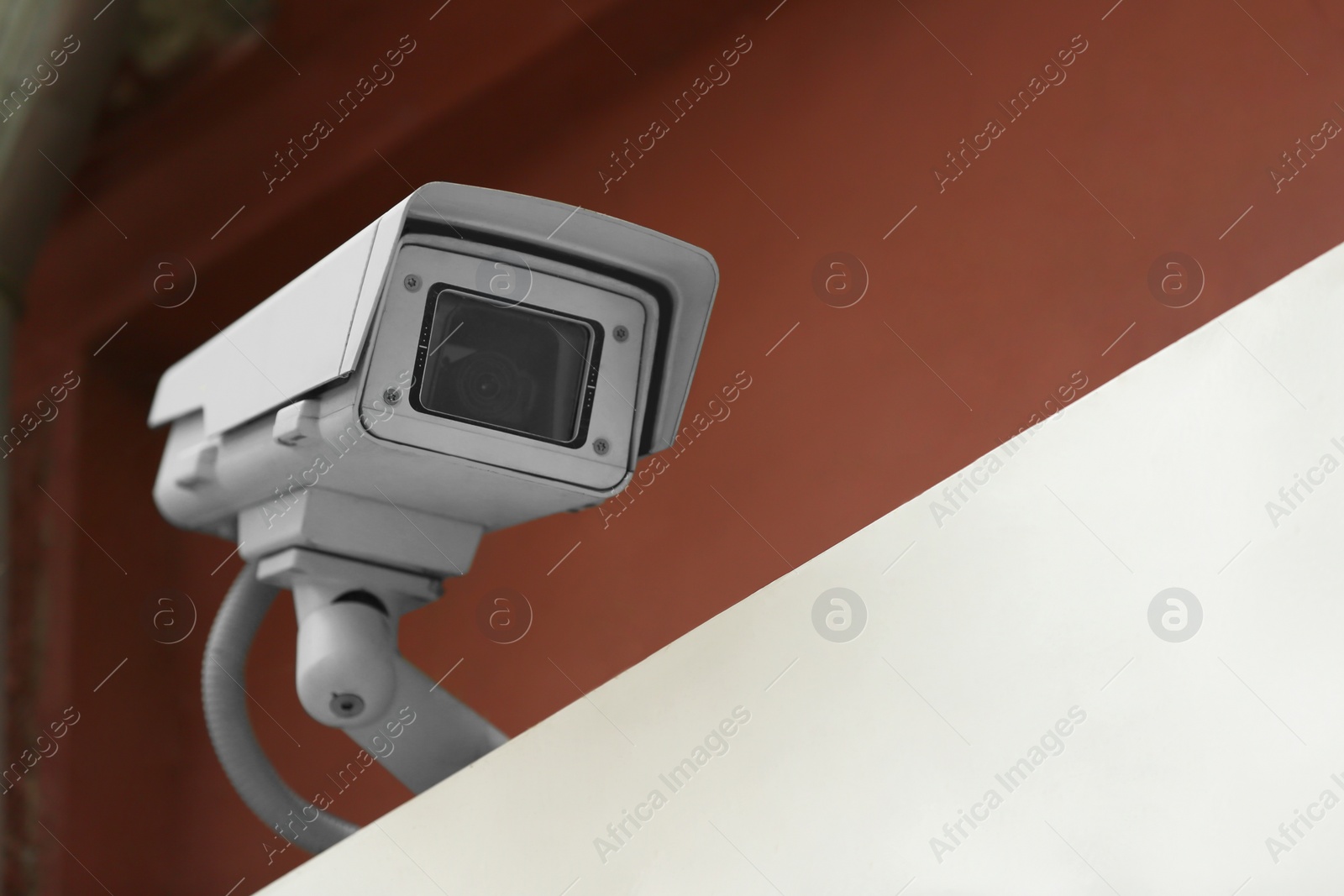 Photo of Modern CCTV security camera on building outdoors. Space for text