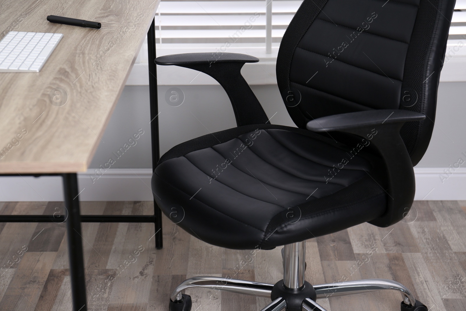 Photo of Comfortable office chair near table in room