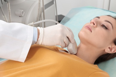 Photo of Doctor conducting ultrasound examination of patient's neck in clinic
