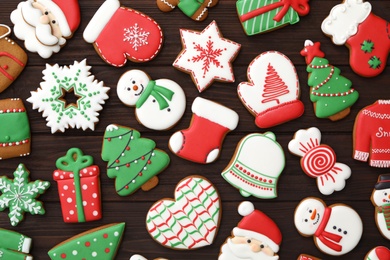 Photo of Many different delicious Christmas cookies on wooden table, flat lay