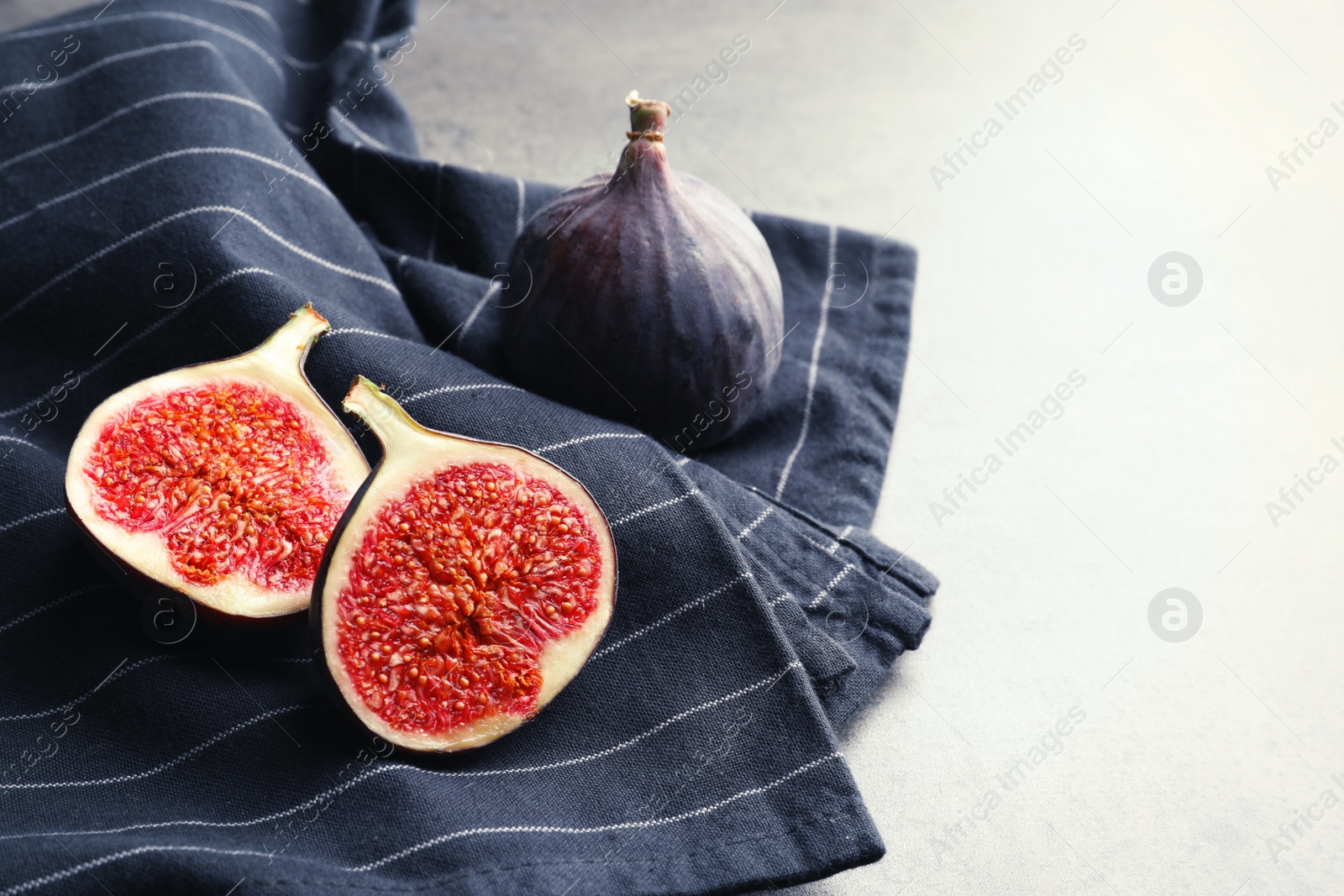 Photo of Fresh ripe sliced figs on fabric. Tropical fruit