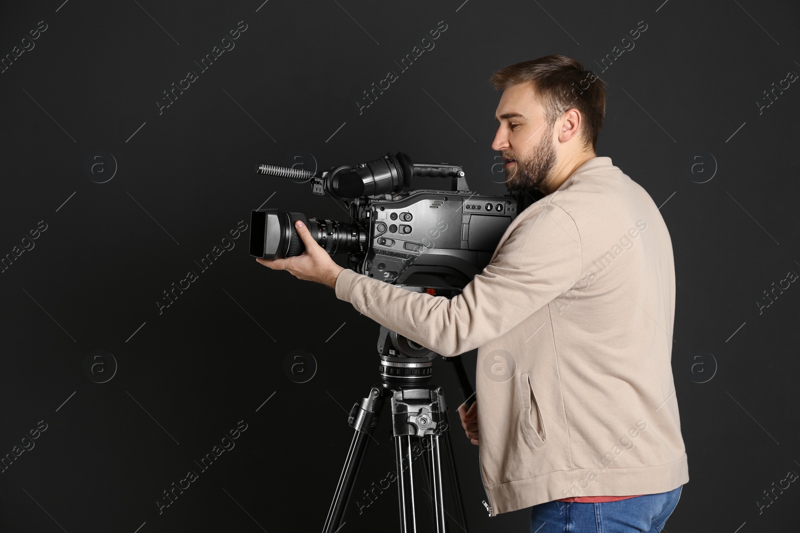 Photo of Operator with professional video camera on black background