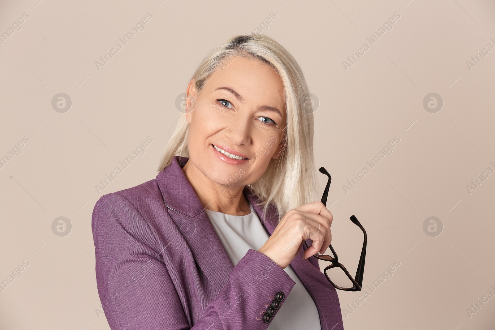 Photo of Portrait of beautiful mature woman with glasses on beige background