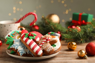 Photo of Delicious Christmas cookies on wooden table against blurred lights