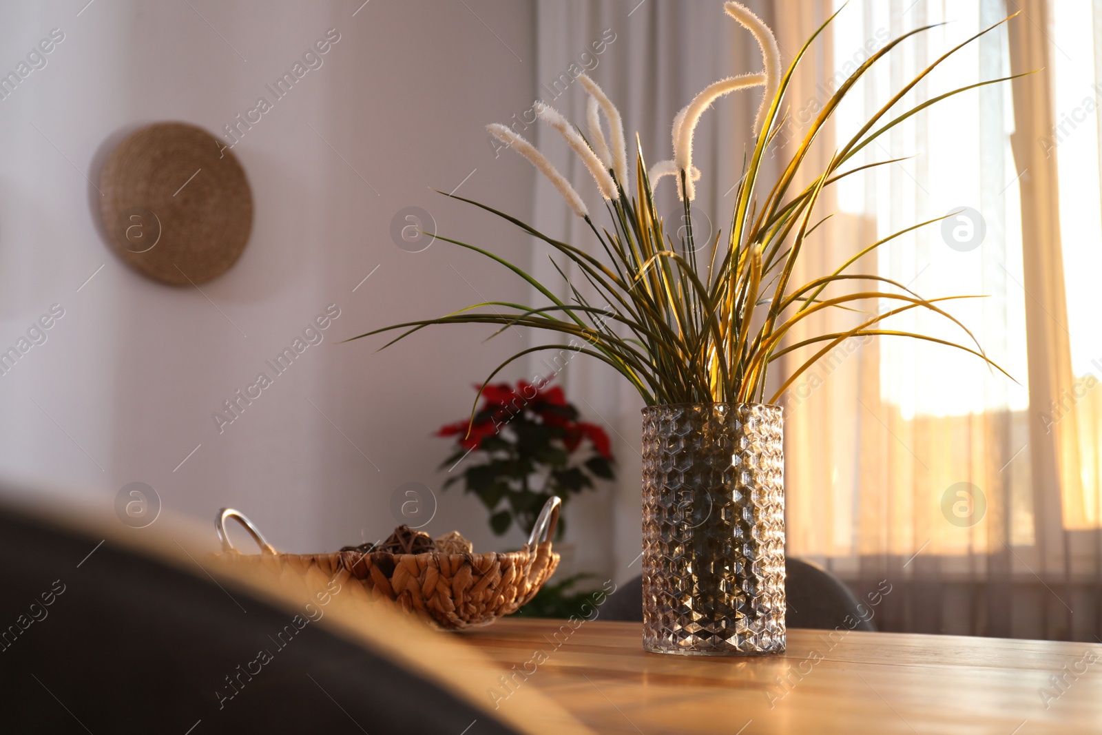 Photo of Vase on wooden table near window with curtains in room