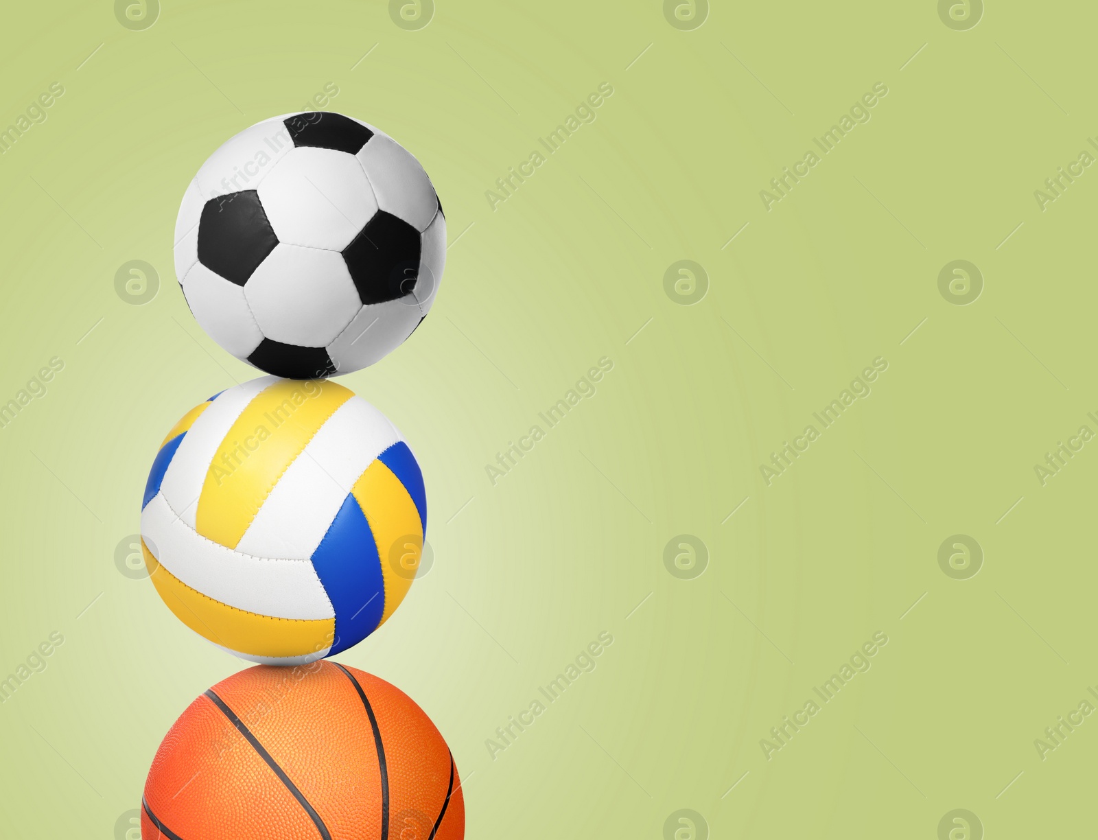 Image of Stack of different sport balls on yellow green background, space for text