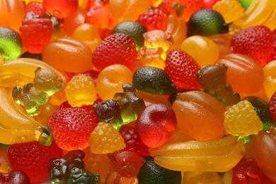 Mix of different delicious gummy candies as background, closeup