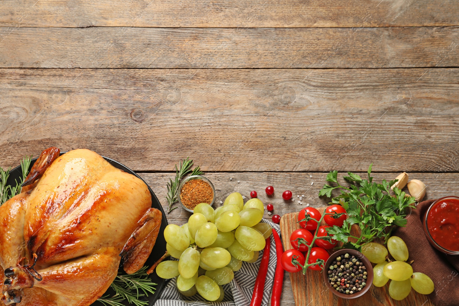 Photo of Flat lay composition with cooked turkey on wooden background. Space for text