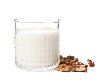 Glass with walnut milk and nuts on white background
