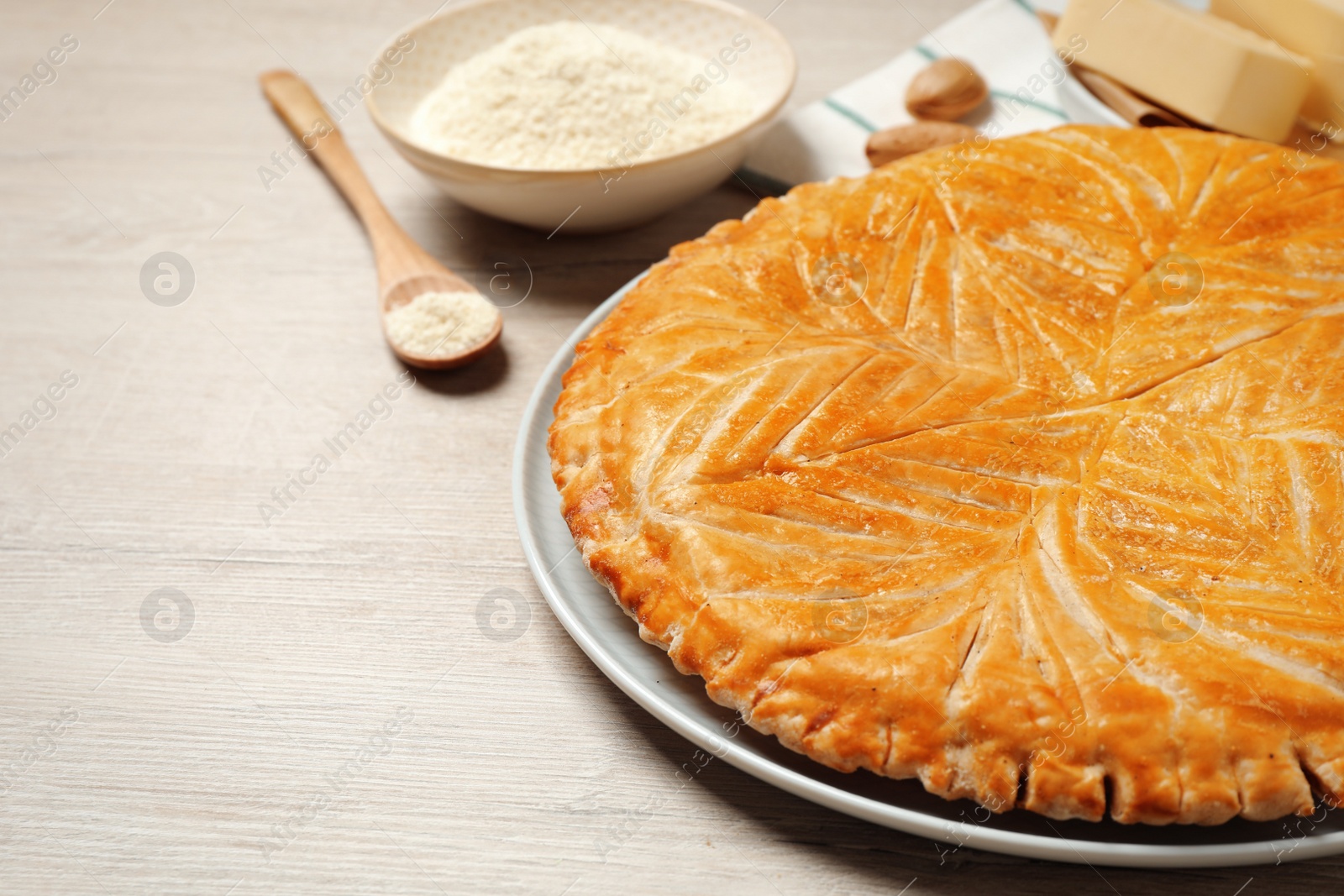 Photo of Traditional galette des rois on white wooden table, closeup. Space for text