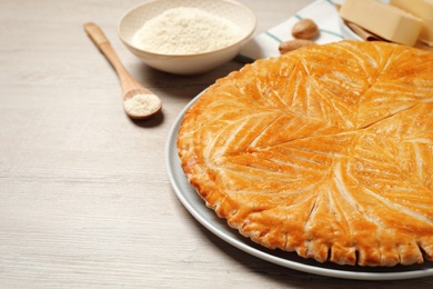 Traditional galette des rois on white wooden table, closeup. Space for text