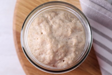 Photo of Sourdough starter in glass jar on light table, top view