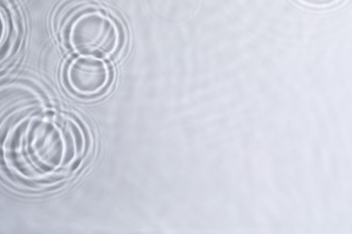Photo of Closeup view of water with circles on light background. Space for text
