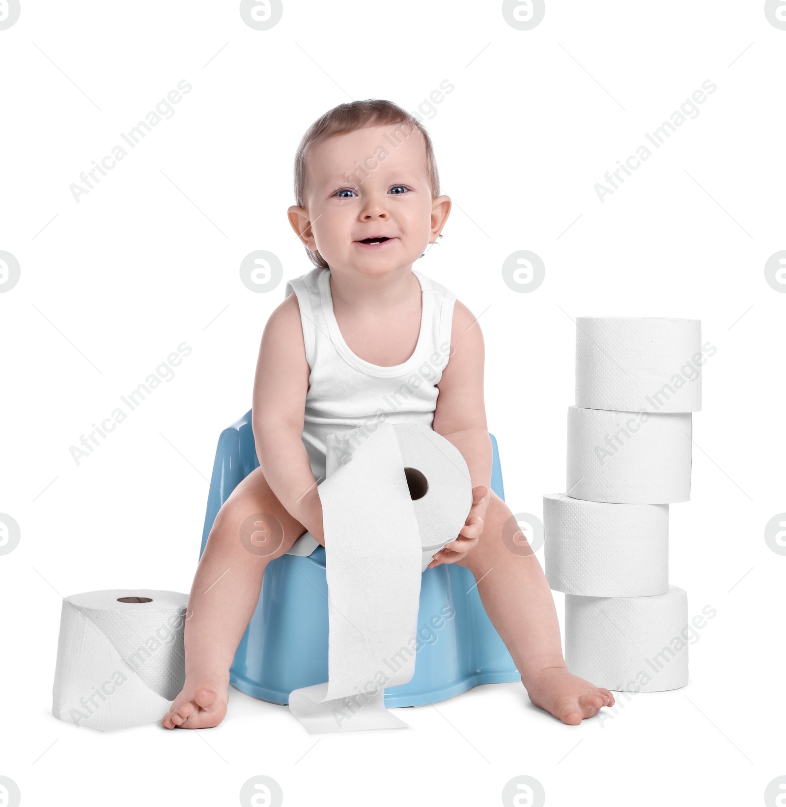 Photo of Little child sitting on baby potty and stack of toilet paper rolls against white background