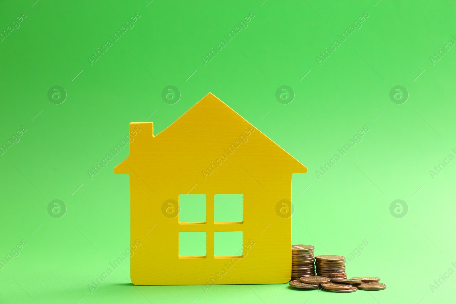 Photo of House figure and coins on color background