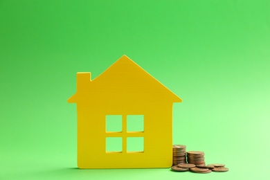 Photo of House figure and coins on color background