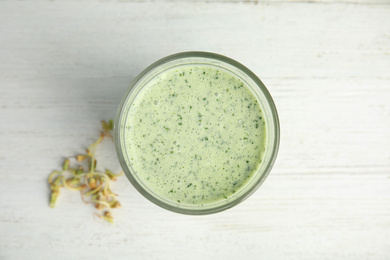 Photo of Green buckwheat smoothie on white wooden table, top view