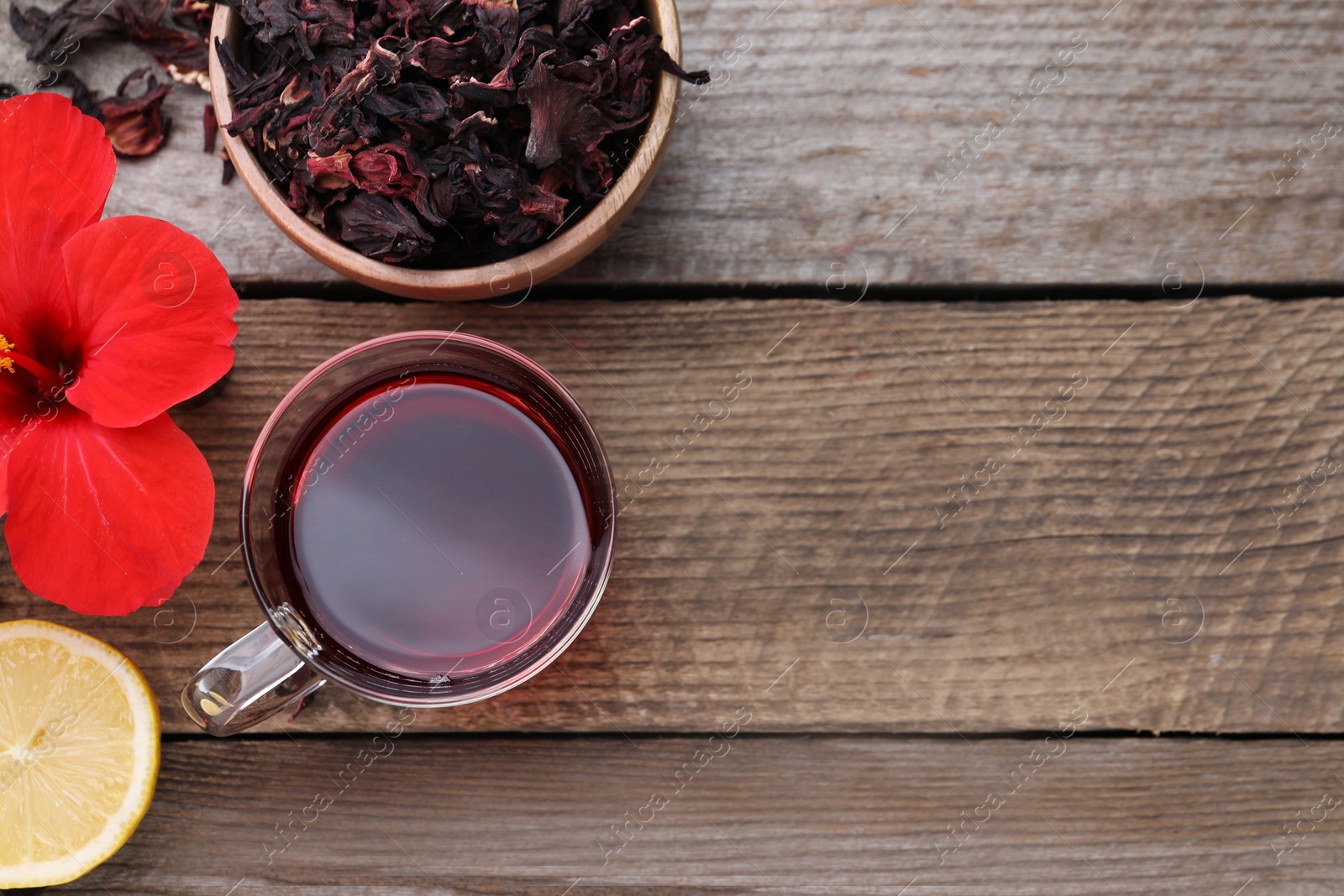 Photo of Flat lay composition with delicious hibiscus tea on wooden table, space for text