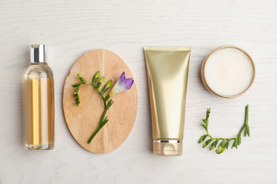 Flat lay composition with cosmetic products on white wooden table