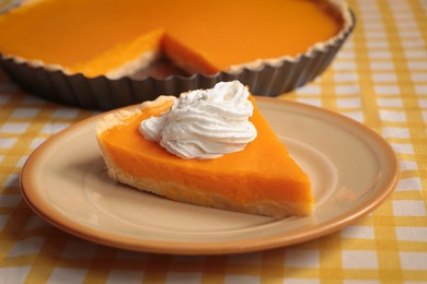 Photo of Piece of fresh homemade pumpkin pie with whipped cream on table