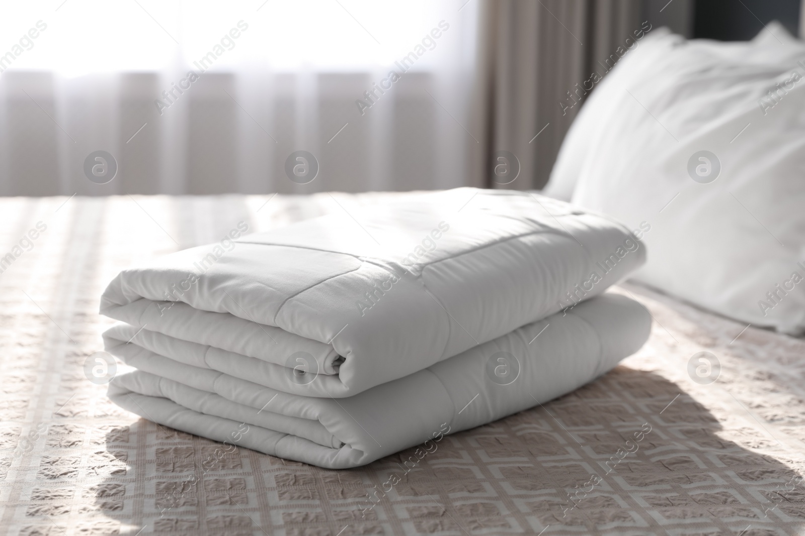 Photo of Folded clean blanket on bed in room