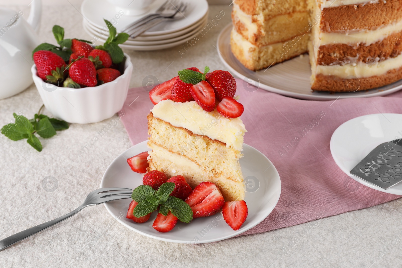 Photo of Piece of tasty cake with fresh strawberries and mint on white table