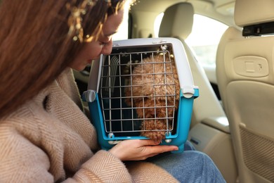 Photo of Woman with pet carrier travelling with her dog by car