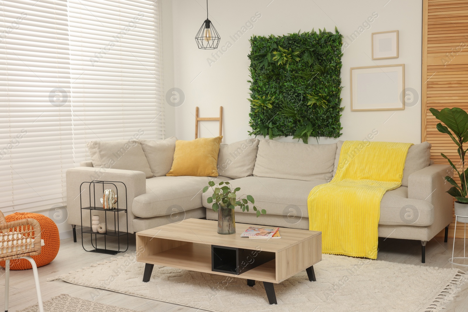 Photo of Green artificial plant wall panel and comfortable furniture in cozy living room. Interior design