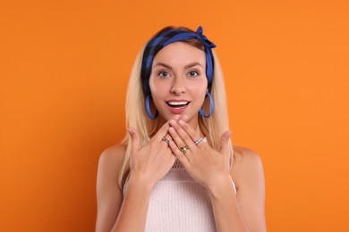 Photo of Portrait of surprised hippie woman on orange background