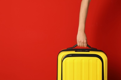 Woman with stylish suitcase against color background, closeup. Space for text