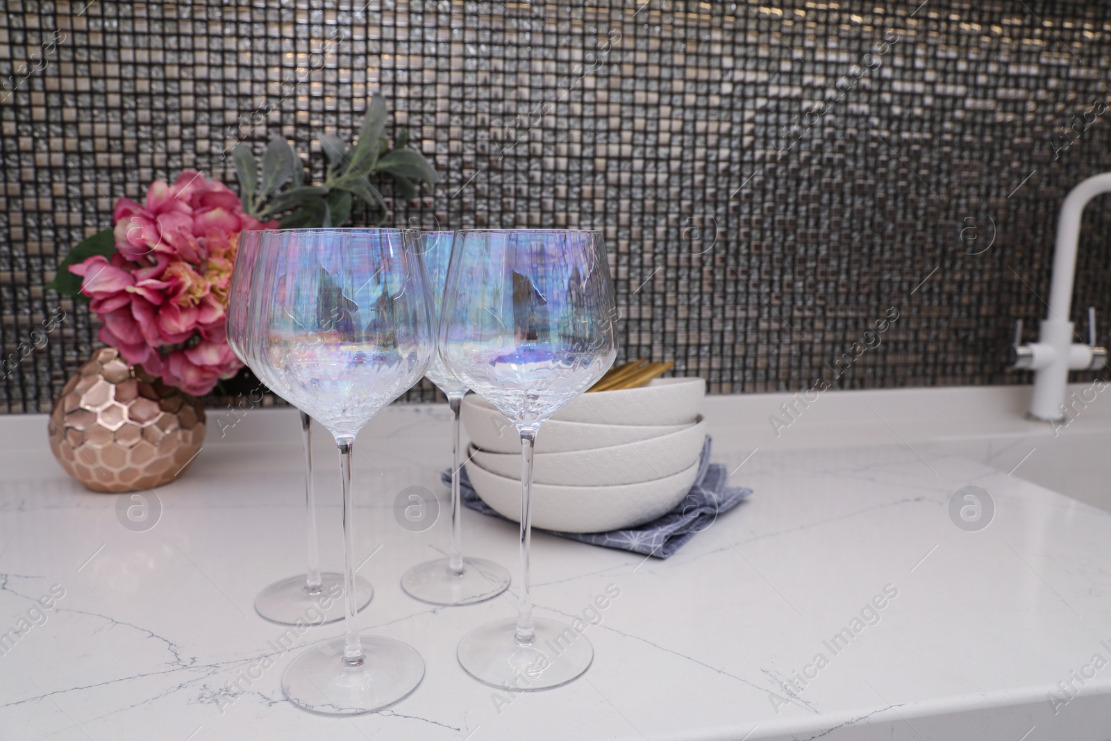 Photo of Beautiful ceramic dishware and glasses on countertop in modern kitchen