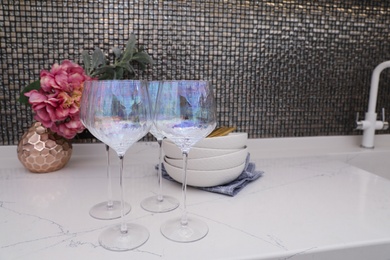 Beautiful ceramic dishware and glasses on countertop in modern kitchen
