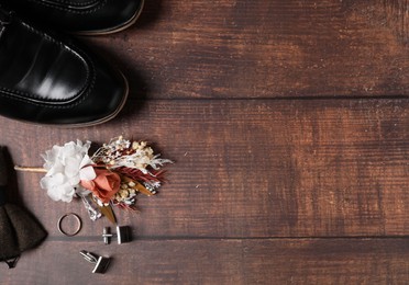 Wedding stuff. Flat lay composition with stylish boutonniere on wooden background, space for text