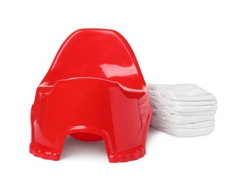 Photo of Red baby potty and diapers on white background. Toilet training