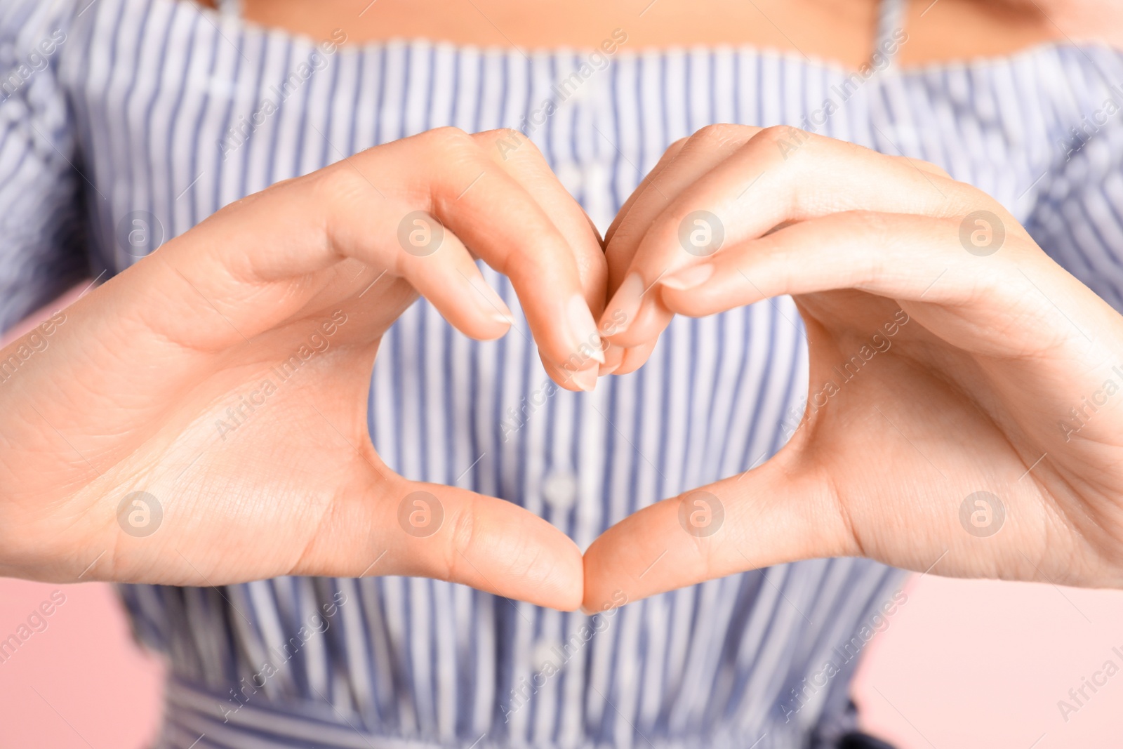 Photo of African-American woman making heart with her hands, closeup