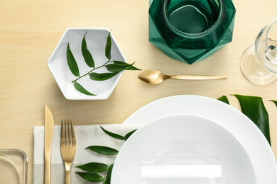 Photo of Elegant table setting with green tropical leaves, flat lay