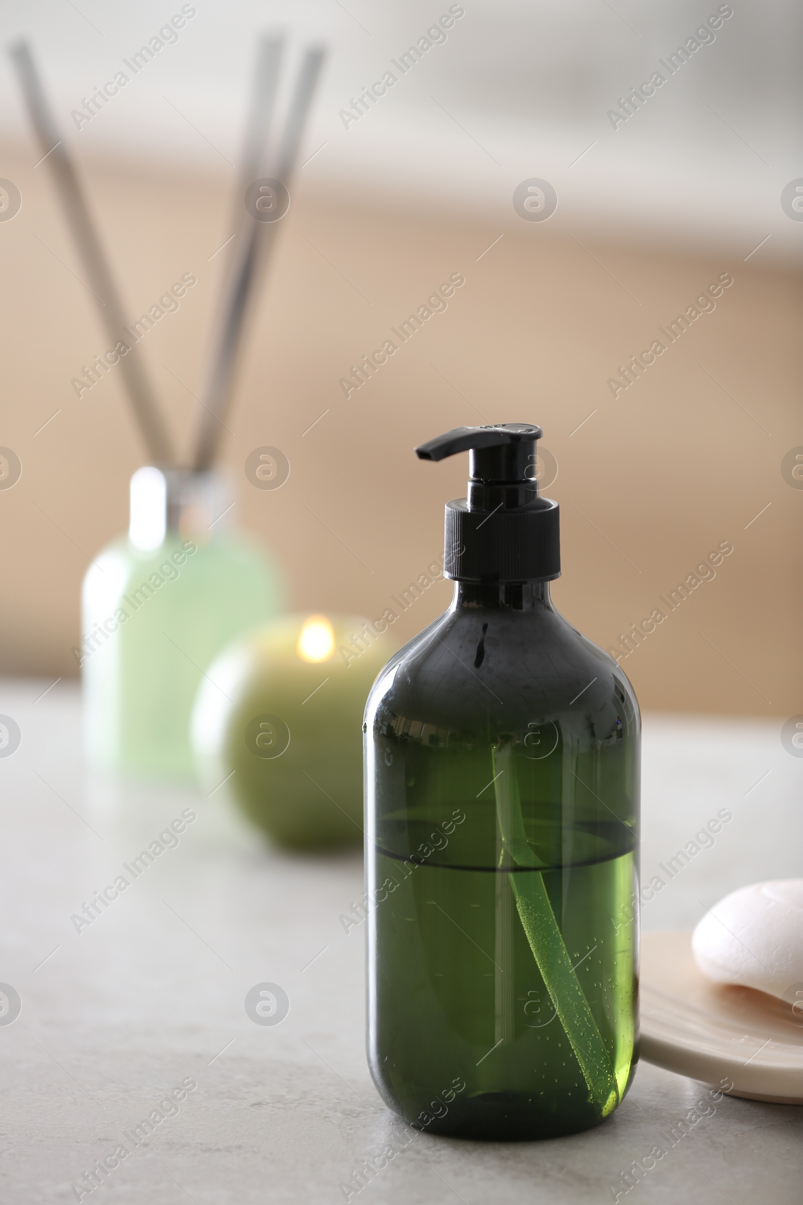 Photo of Green soap dispenser on white countertop in bathroom