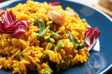 Photo of Delicious rice pilaf with chicken and vegetables on plate, closeup