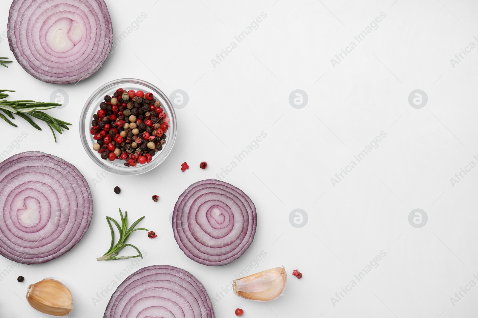 Photo of Fresh red onions, garlic, rosemary and spices on white background, flat lay. Space for text