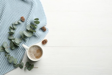 Photo of Flat lay composition with coffee and warm plaid on white wooden table, space for text